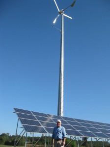 Wes Carter in front of a wind tower and solar array.