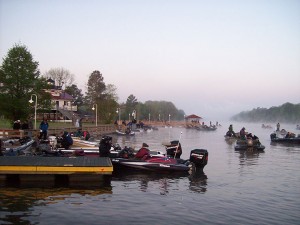 Visitors sit on boats near a dock.