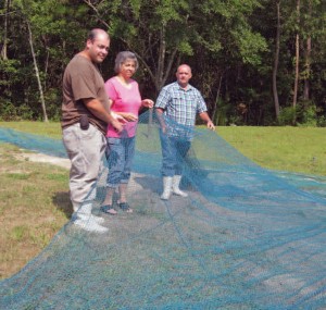 From left, Eric, Devonda and Dolphus Thompson of Sneads Ferry check nets for the family business.