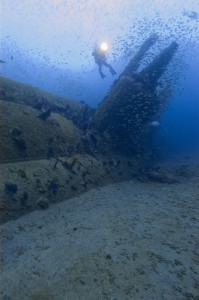 A diver hovers above the wreck of the U-352 submarine.