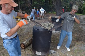 Agusta Varnam and Terrence Galloway lift grill of oysters during roast.