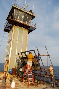 Richard Neal and volunteer David Wood attach solar panels to Frying Pan Tower.