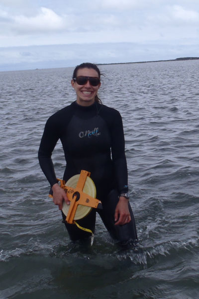 Danielle standing in the water in wetsuit