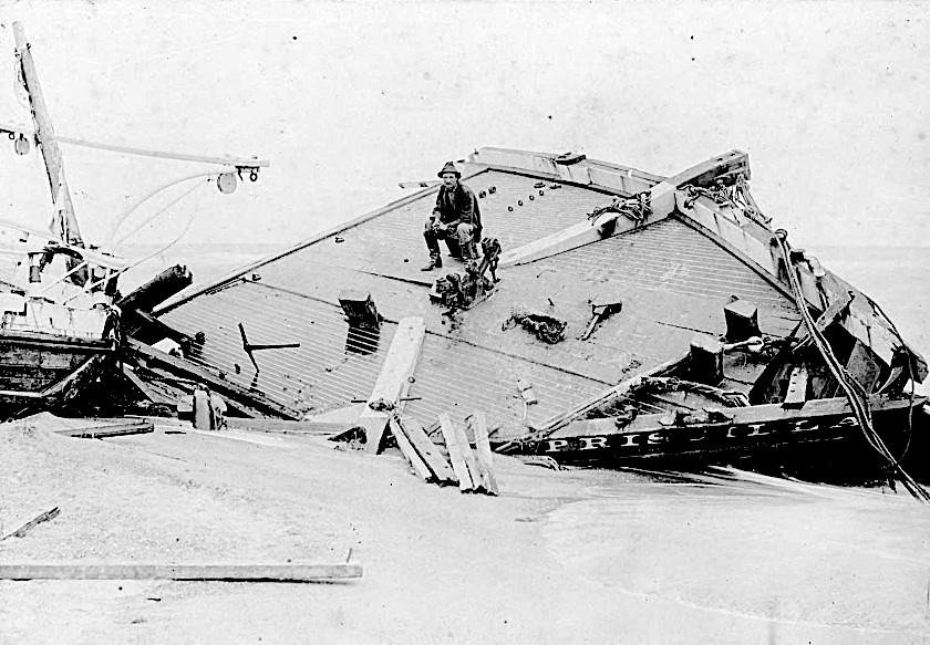 Rasmus Midgett sits on the wrecked remains of the Priscilla. From the H. H. Brimley Collection.