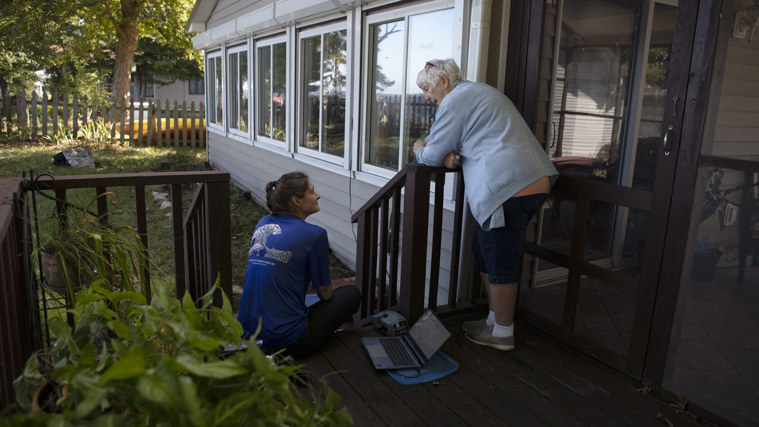 a water quality researcher and a community member talking on a porch