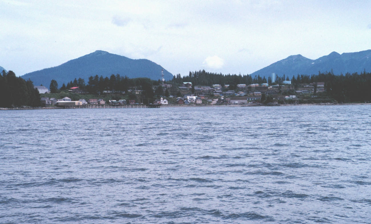 A coastal village with mountains in the background.