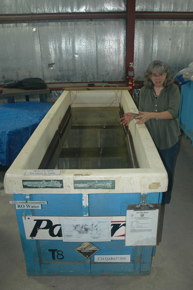 Sarah Watkins-Kenney stands next to tank with a cannon in it.