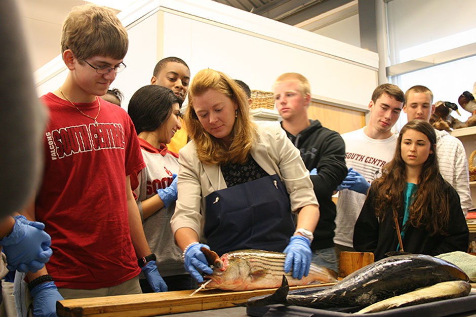 George Pate and his classmates watch Coley Hughes open a striped bass skull.