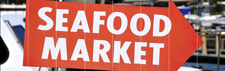 Red arrow-shaped sign pointing way to Seafood Market