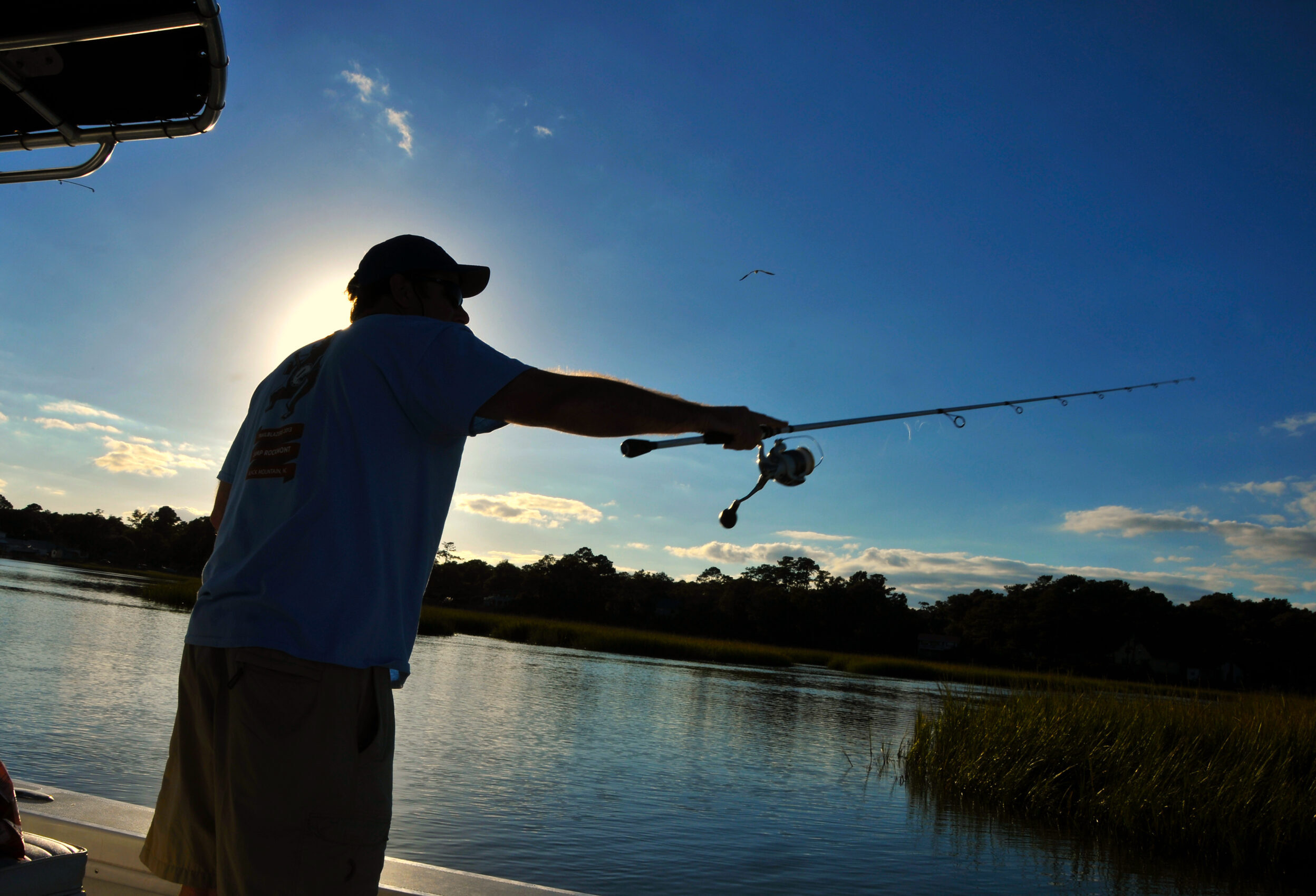 image: Fisherman casts up in the Shallotte River as the sun sets in early Fall.