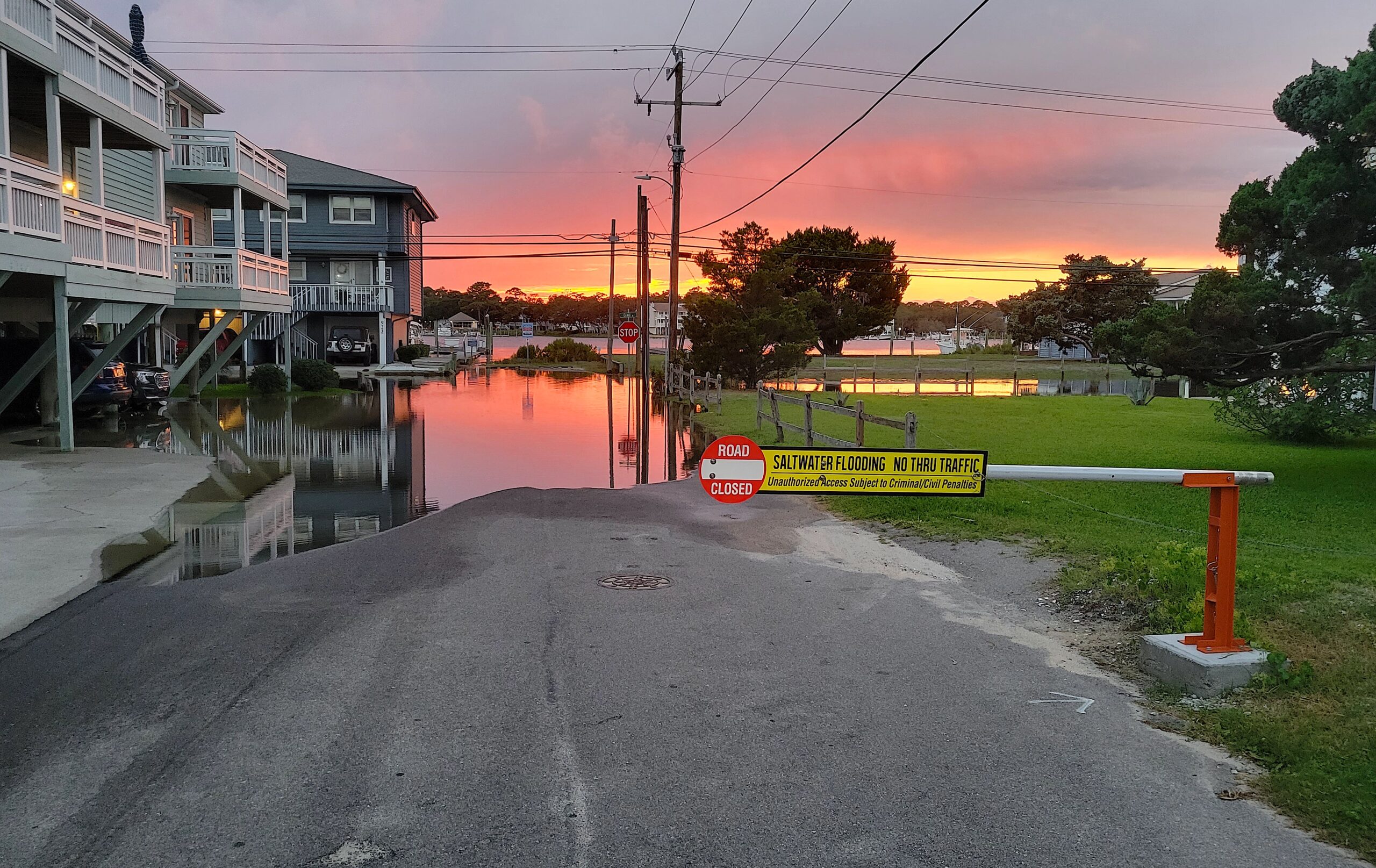 image: flooded residential street at sunset.