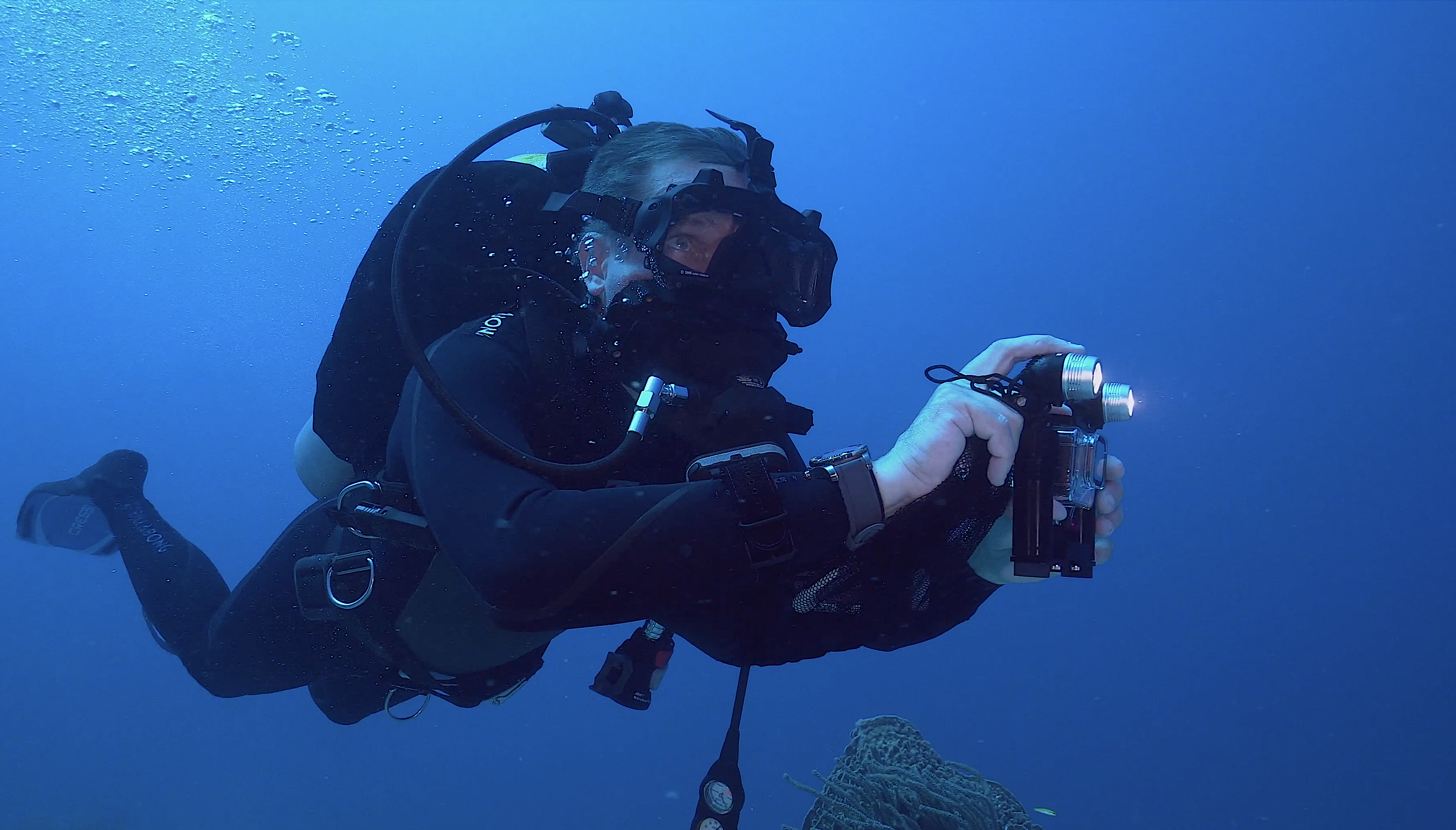 image: Fabien Cousteau in diving gear underwater.