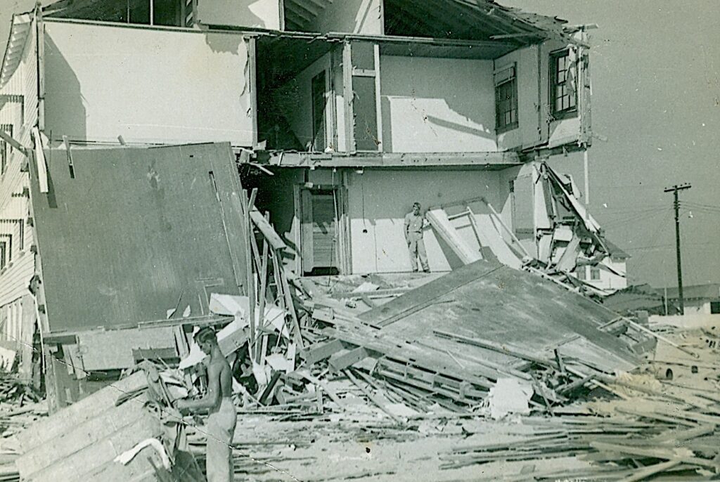 image: collapsed house.