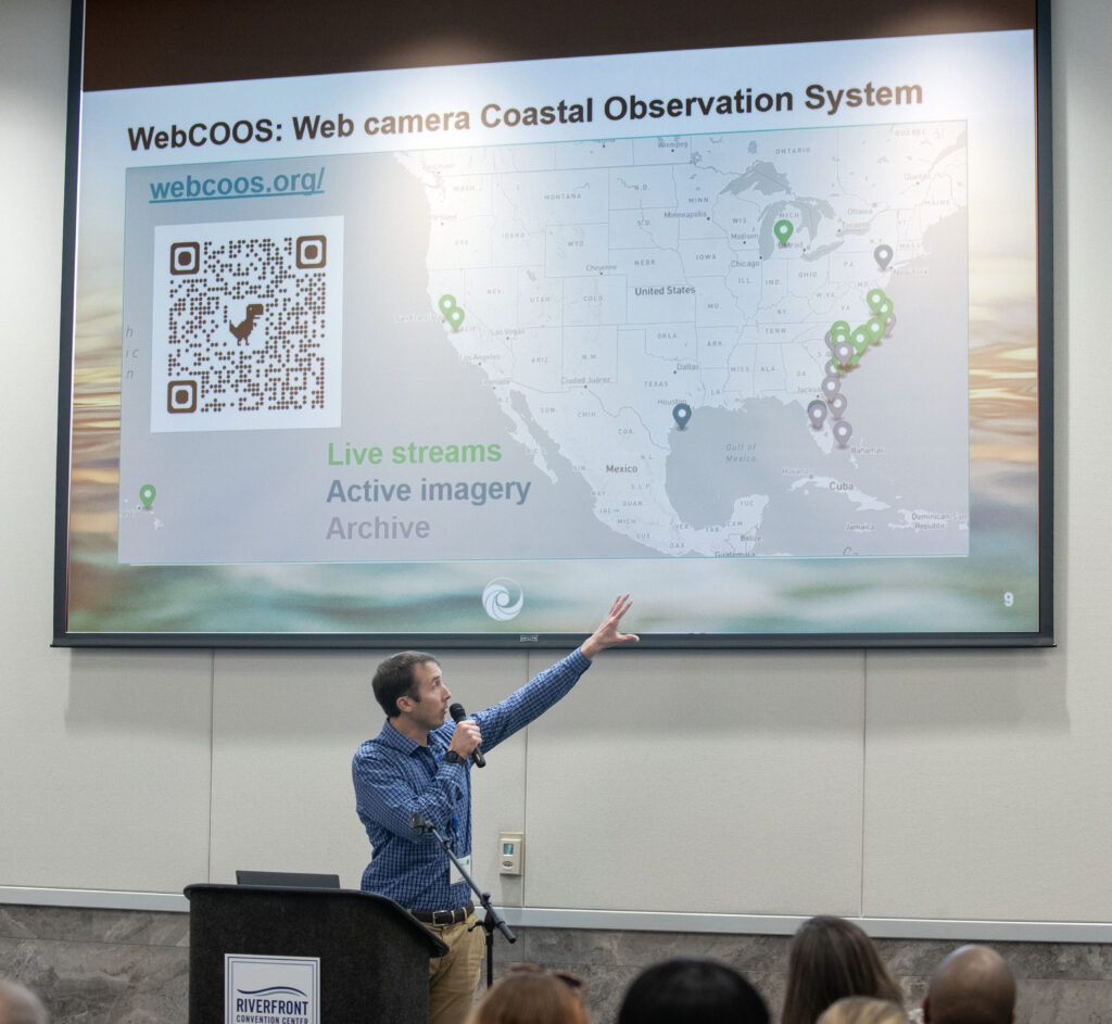 image: Theo Jess, SECOORA, talks about using web cameras to monitor water levels during the afternoon research presentations at the 2024 North Carolina Coastal Conference.