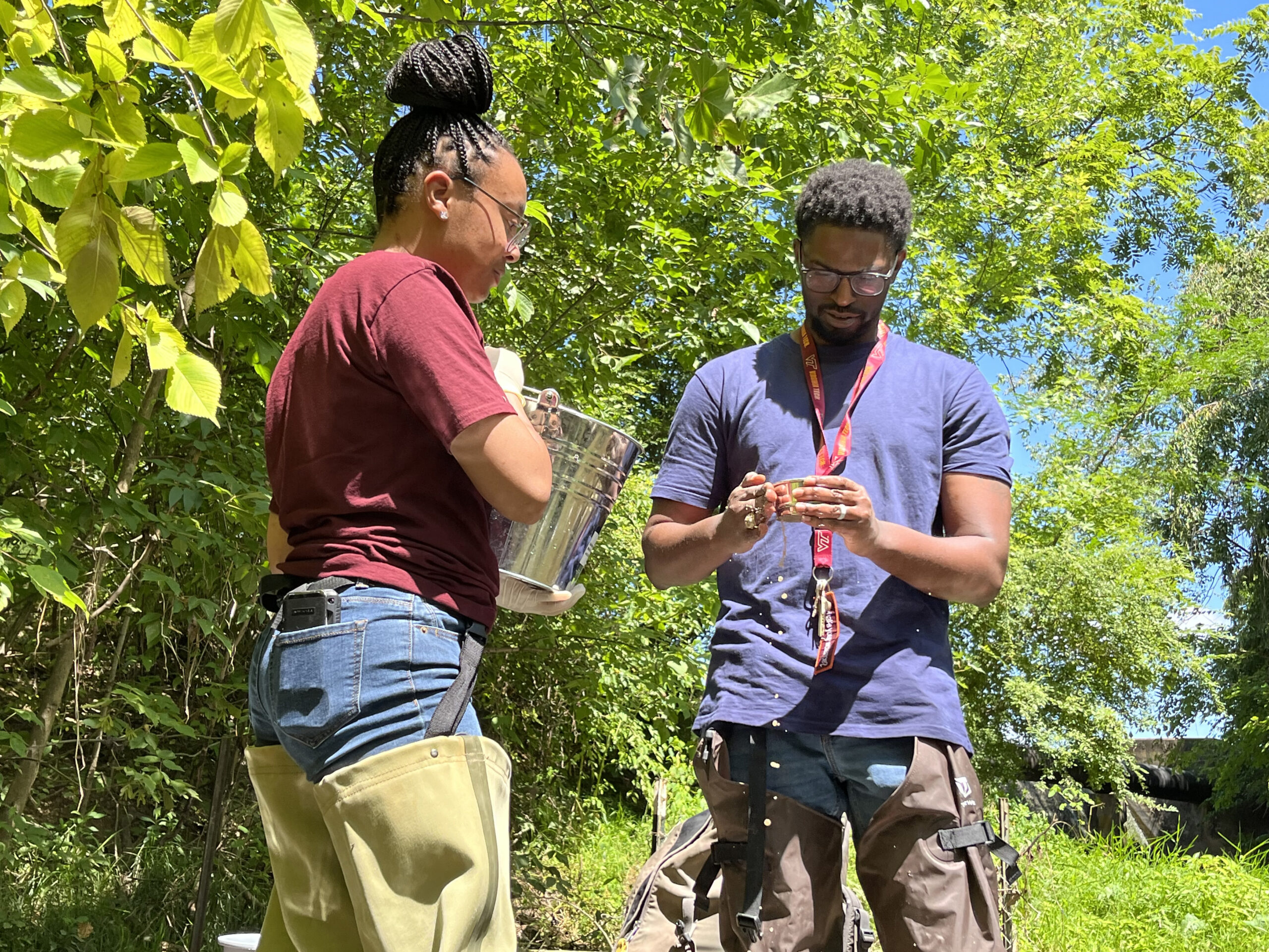 Austin Gray with a student conducting fieldwork at a creek.