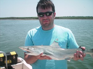 Bangley holds a finetooth shark that he caught in South Carolina.