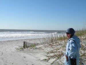 Susan White stands on an oceanfront beach in a winter jacket.
