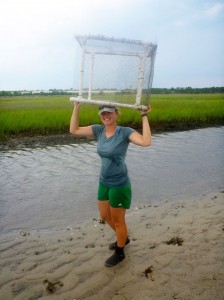 Gittman holds a marsh sill above her head.