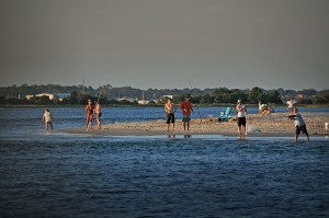 People standing on a beach and fishing.