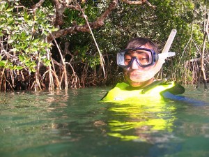 Student with goggles and a snorkel in water.