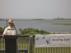 Voiland speaks in front of a sign for the North Carolina Birding Trail.