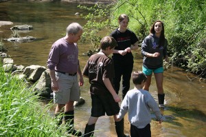 John Godwin (left) and Slane (third from left) wade into the water to help young workshop participants gather water samples. 