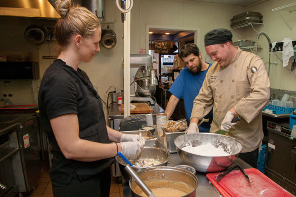 From left to right, Johanna Lachine, Justin Lachine and Eric Whidbee prepare cape shark at Café Lachine. Photo by Jim Trotman