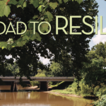 Photo of a bridge crossing over the Neuse River in Kinston. The title of the article, "The Road to Resilience," overlays the photo, along with the author's name, Julie Leibach.