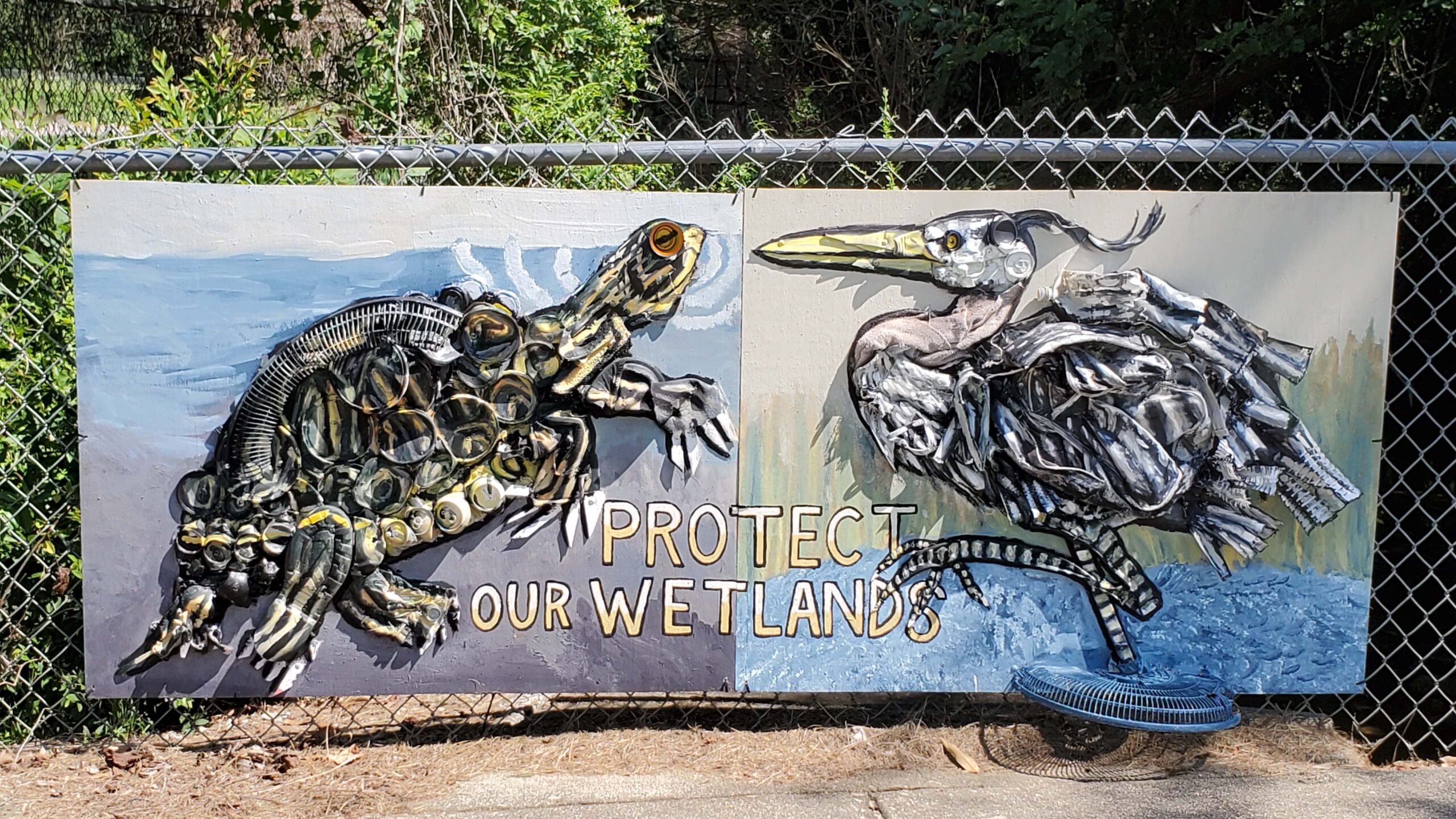 A sign featuring a turtle and a heron adorned with debris collected from Walnut Creek in Raleigh.