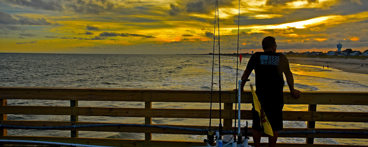 Fisherman pauses for a moment to watch the sun set from Oceanna Fishing Pier in Atlantic Beach.
