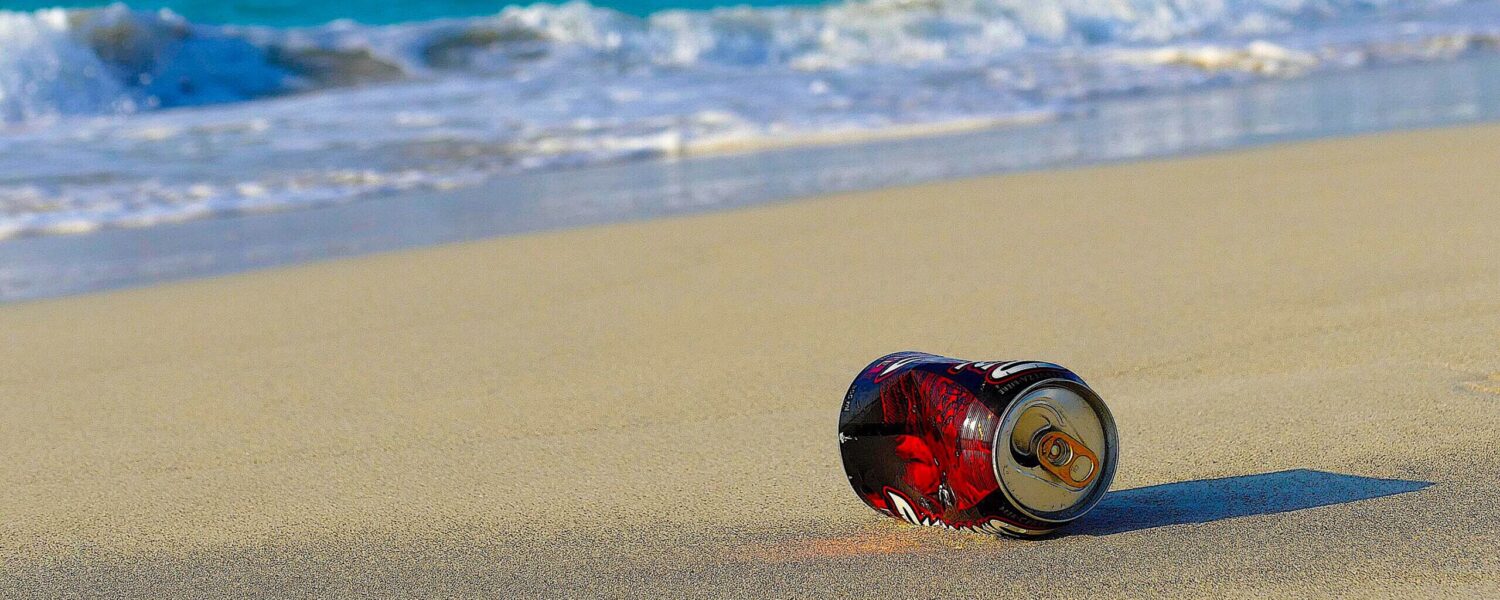 image: coke can on the beach.