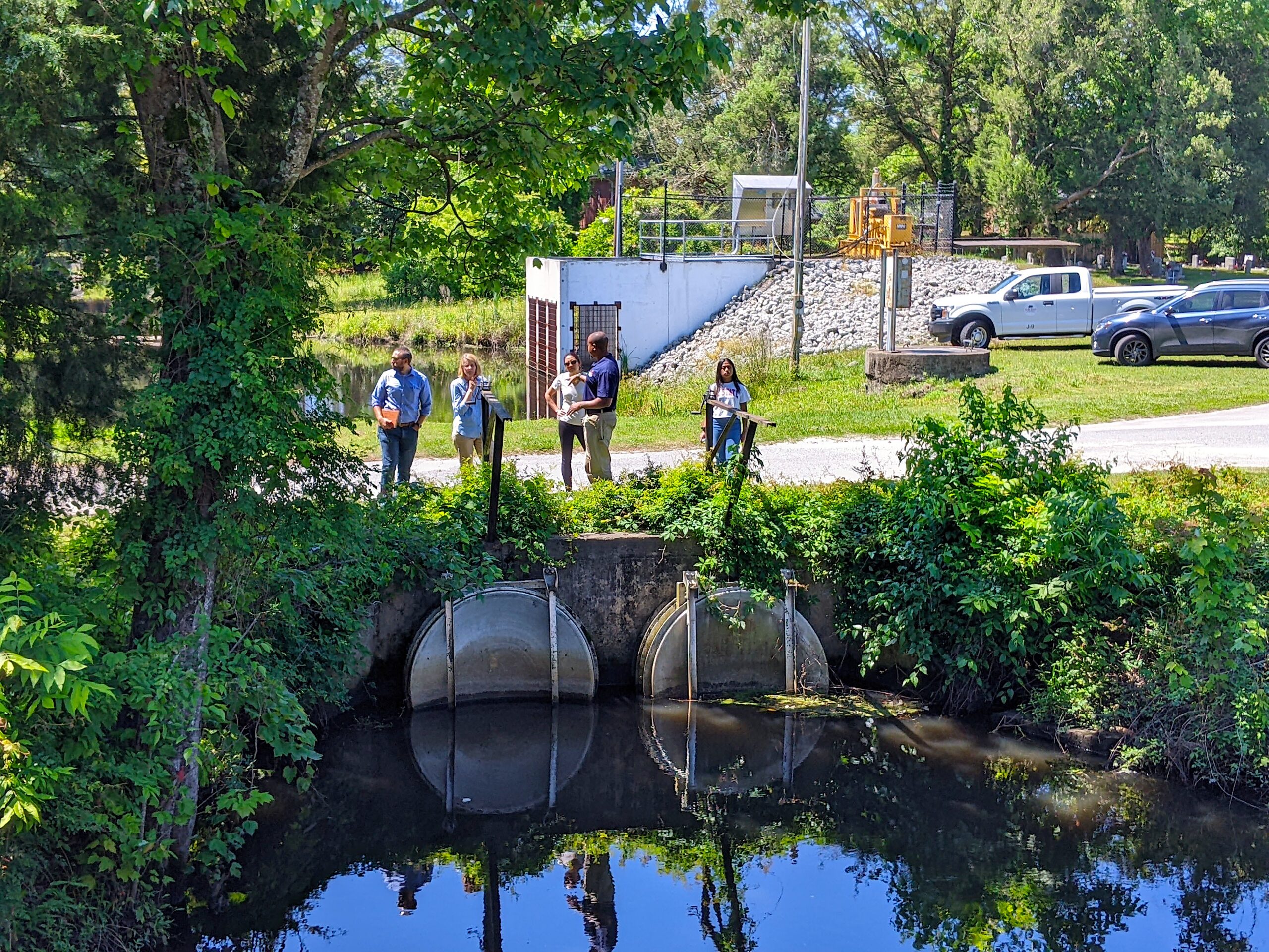image: a group of people tour a stormwater facility with a New Bern official. 