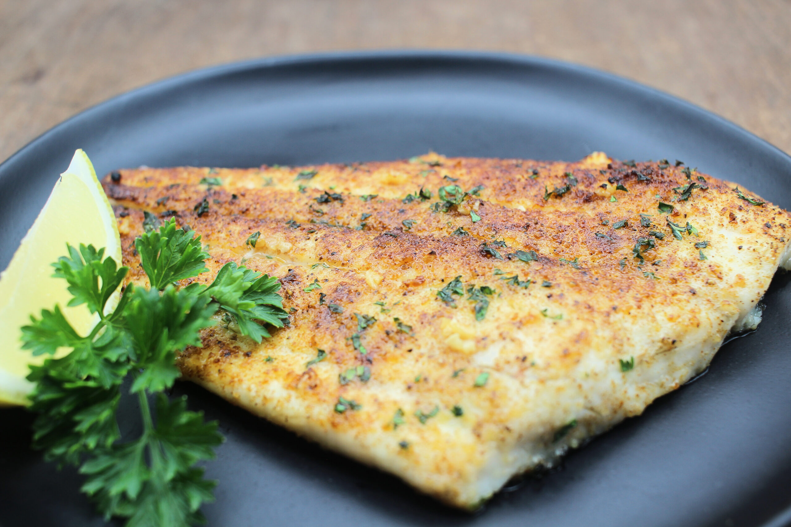 Broiled fish fillet with garlic and parsley.