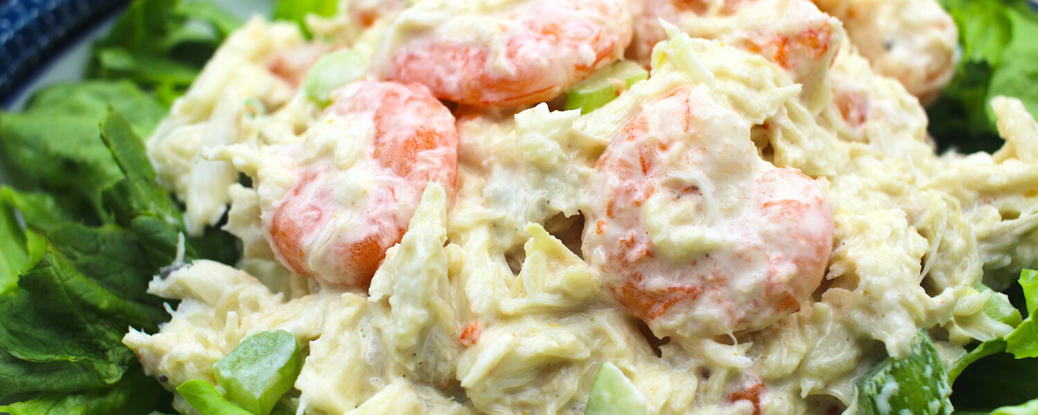 image: crab and shrimp salad on lettuce bed.