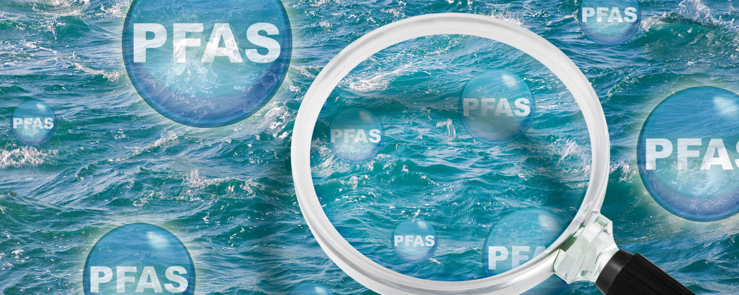 image: graphic of a magnifying glass over water with bubbles that say "PFAS".
