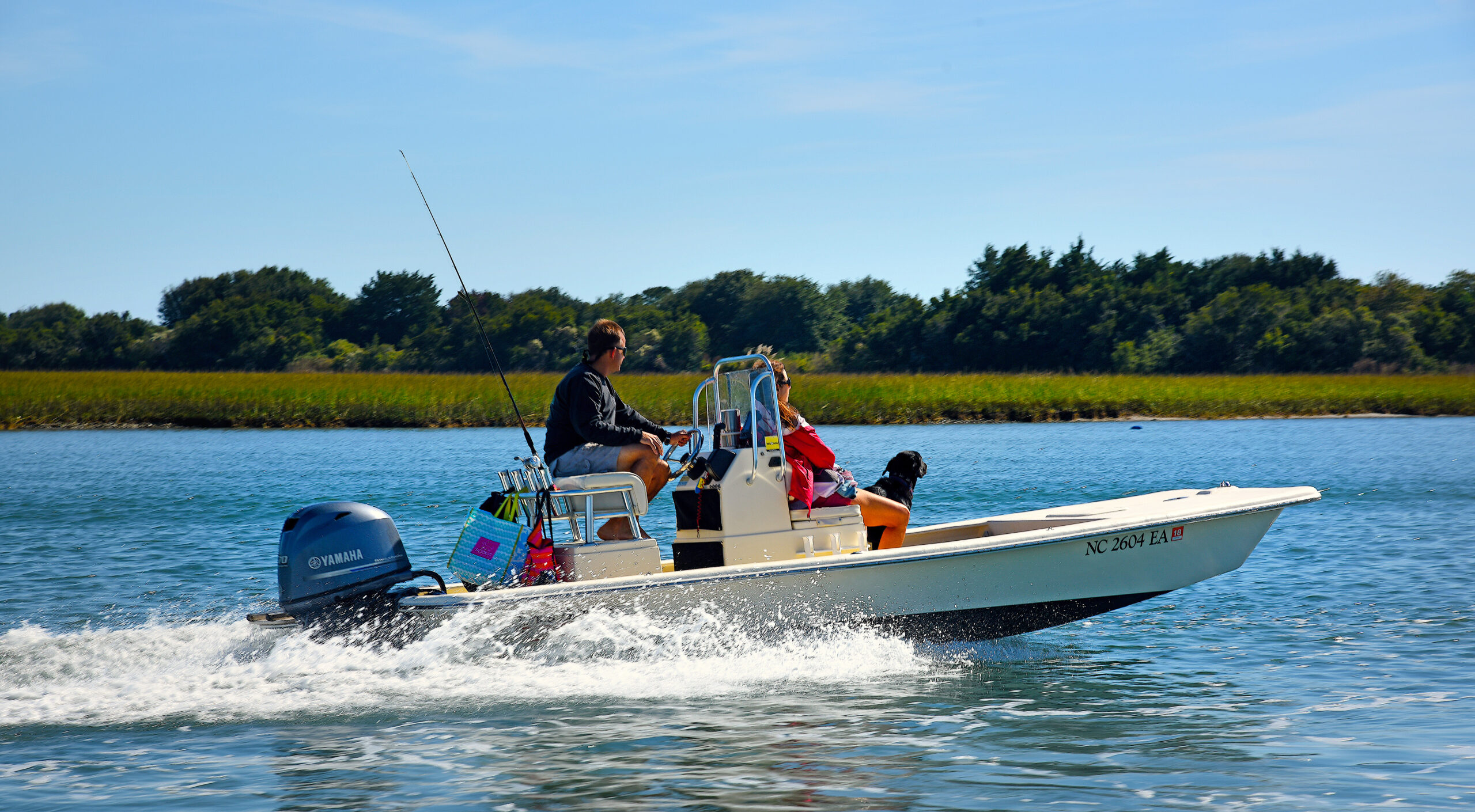 image: Boaters and their dog speed south down the Intracoastal Waterway near Figure Eight Island.