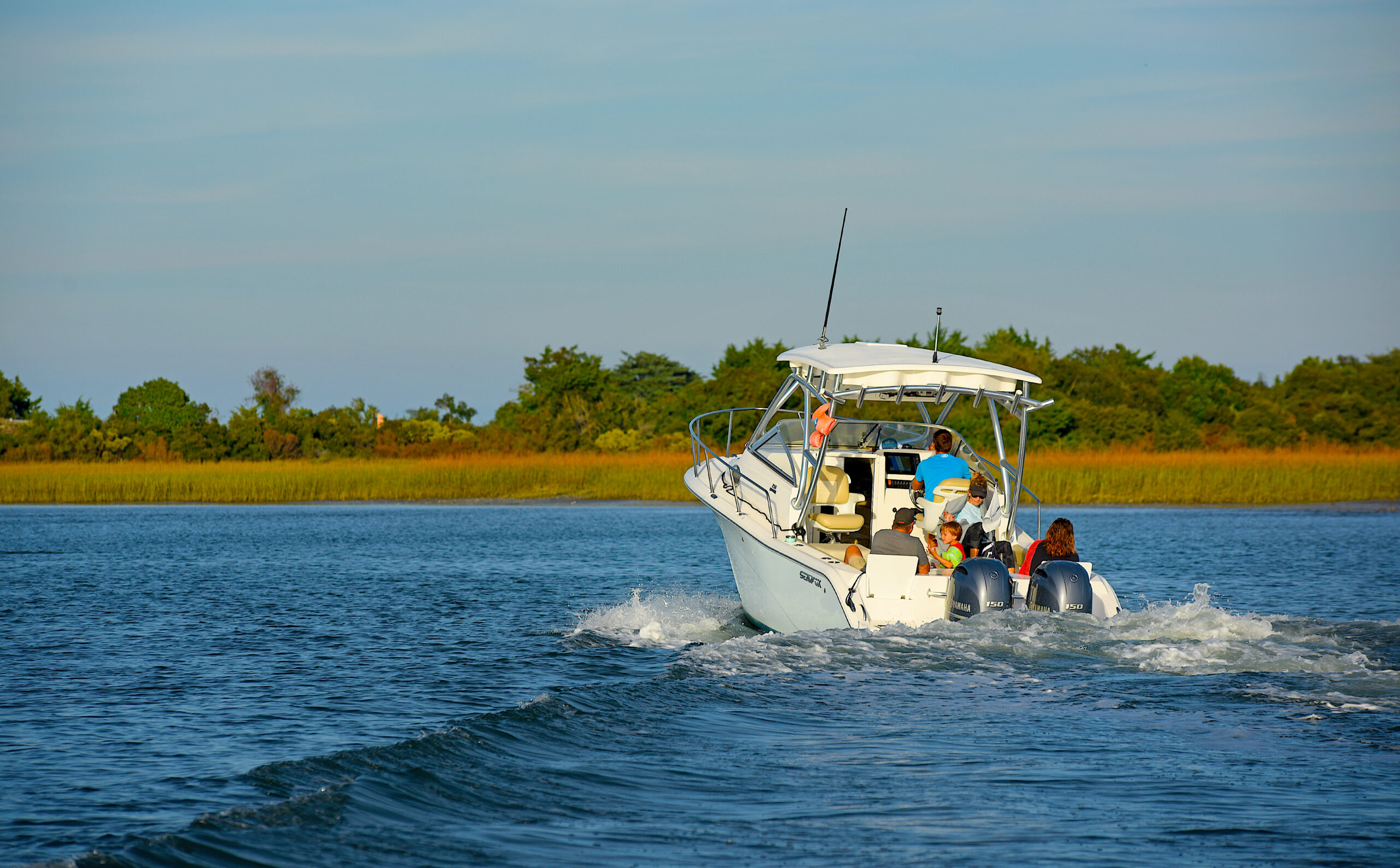 image: Recreational boater family cruises the ICW behind Figure Eight Island.