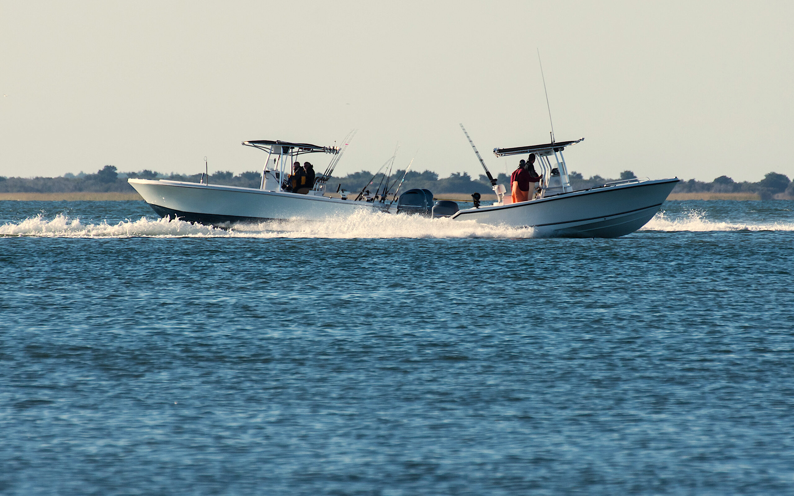 image: two boats full of fishers on NC waters.