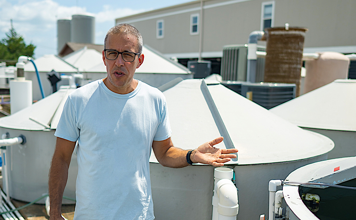 image: UNCW's Patrick Carroll at the aquaculture tanks, by D DiNicola.