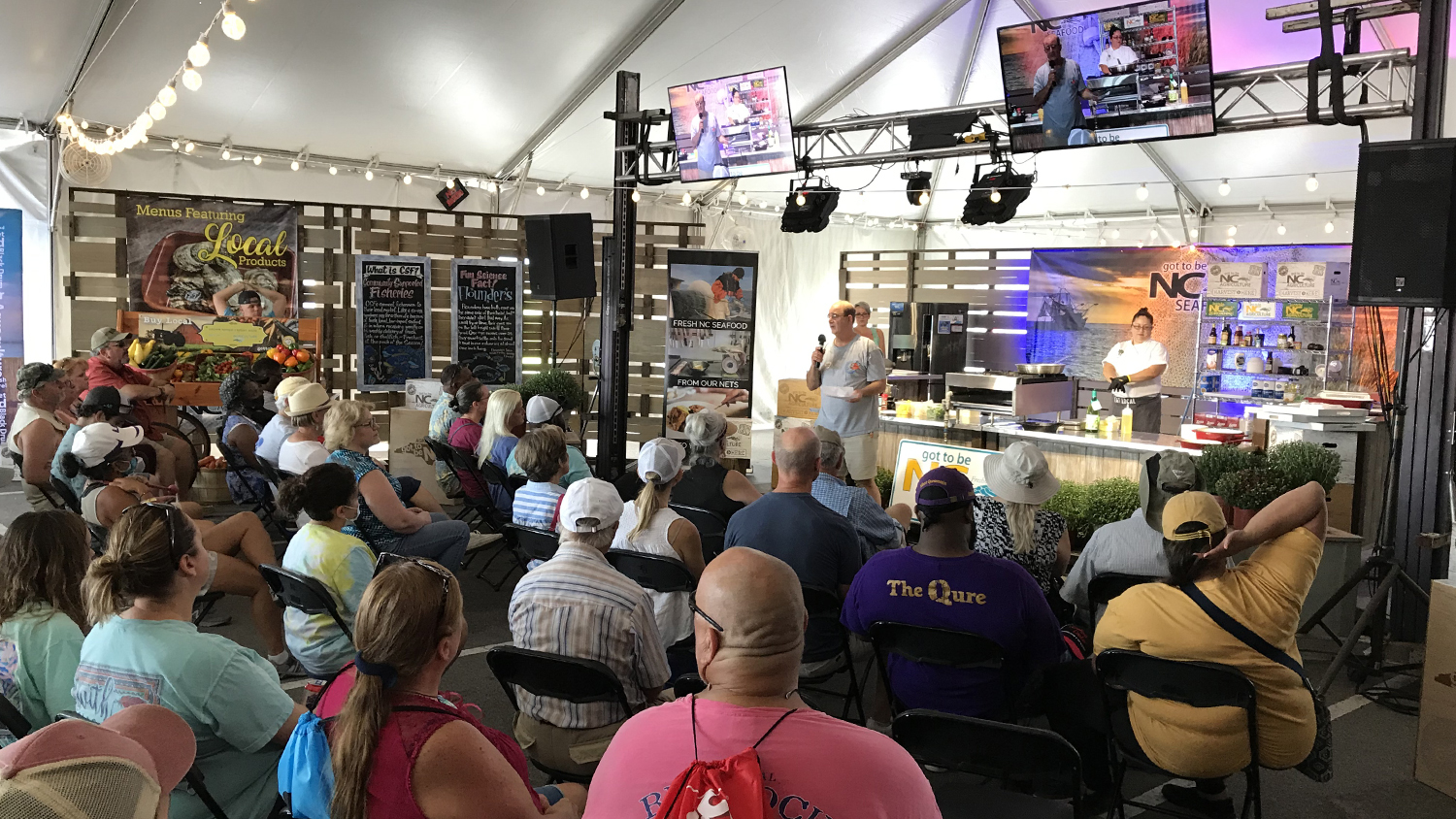 Barry Nash gives a presentation on striped bass to a large seated crowd at the NC Seafood Festival