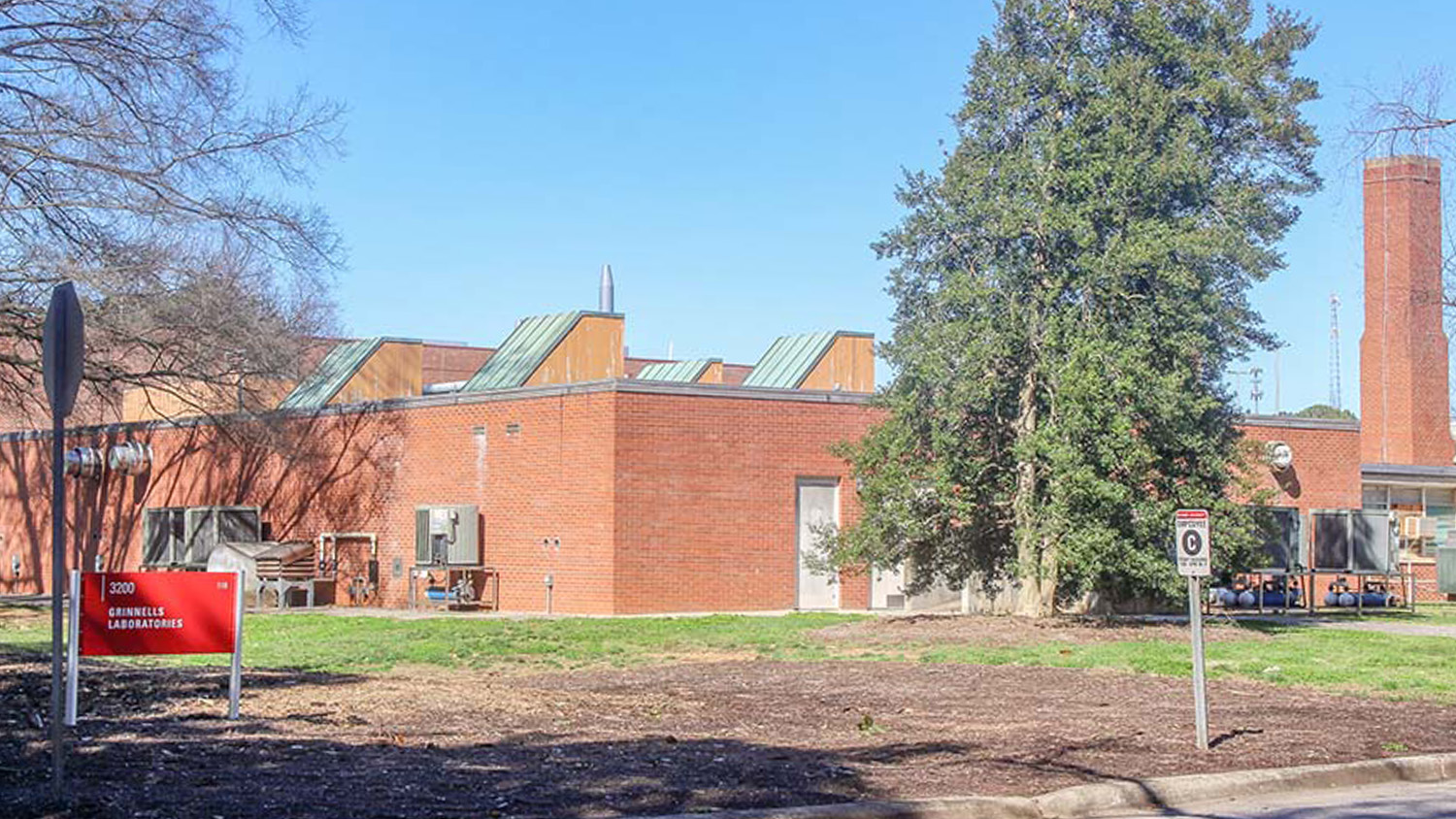 A large brick building with trees in the foreground