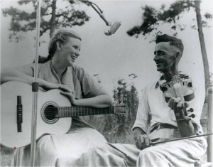 Woman on guitar and man on fiddle, black-and-white photo