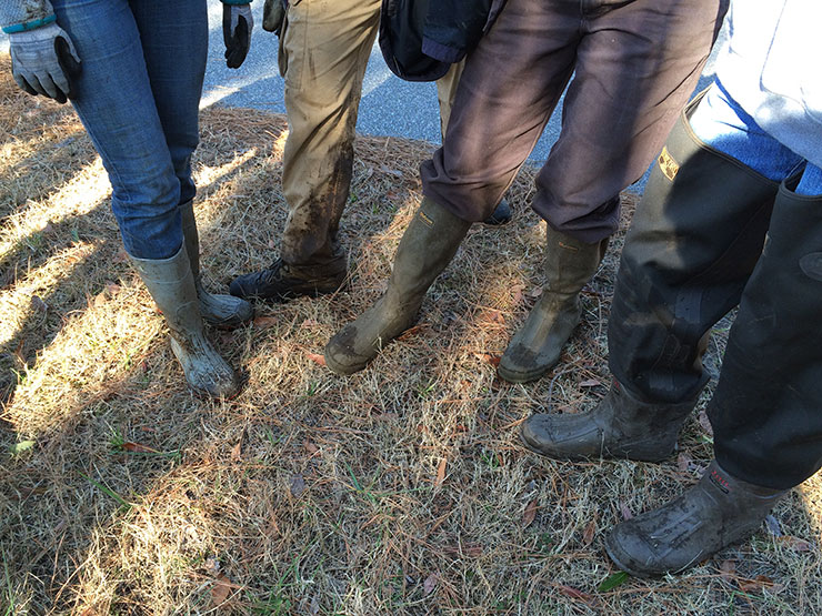 Volunteers show muddy boots.