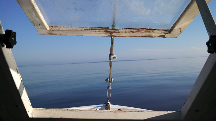 View of calm water out of window on boat.