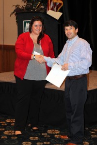 Renee Pellitier accepts the first place poster contest prize from John Fear during the 2016 Graduate Communications Symposium.
