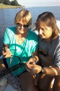 Two women looking at Hydrilla, an invasive aquatic weed