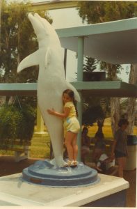 Tightly hugging a dolphin at the Miami Seaquarium, young Sara 