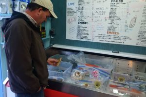 Man looking at products in seafood market