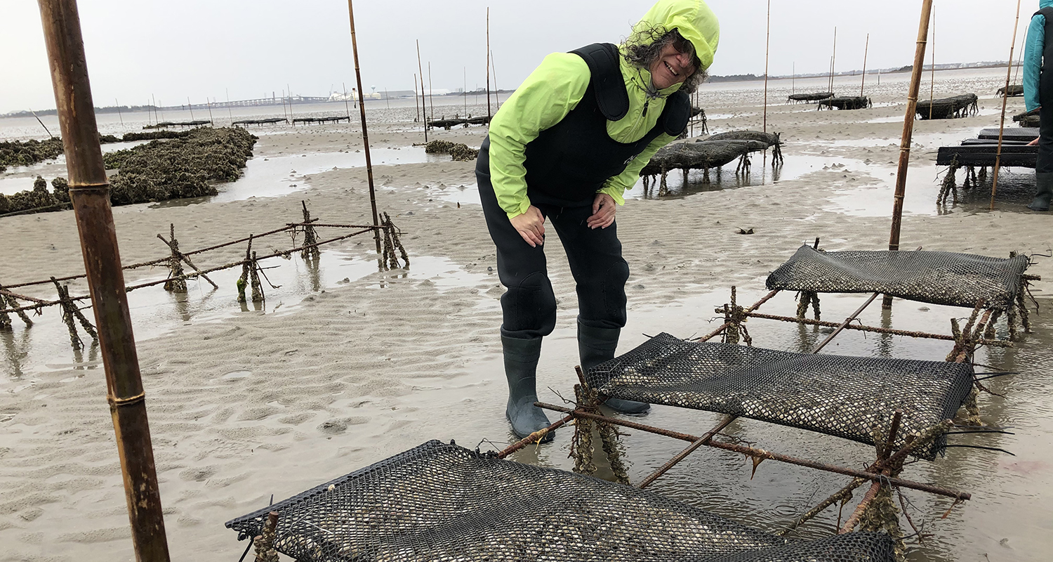 Carla Barbieri of Cary, North Carolina, observes oysters in production on a shellfish farm tour in early March. Photo by Jane Harrison