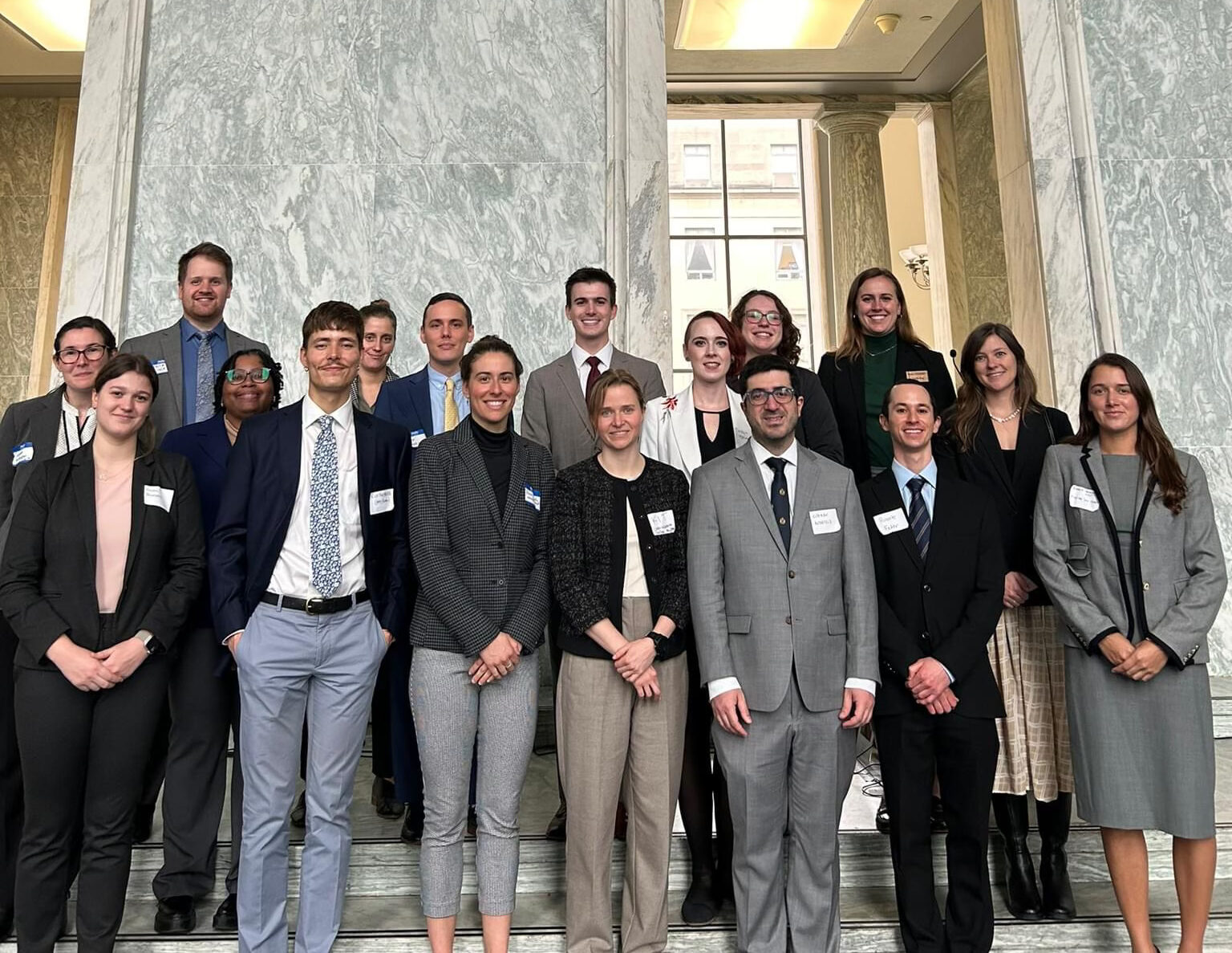 The 2024 Knauss Fellows chosen to serve in their legislative placement offices stand in front of two doorways.